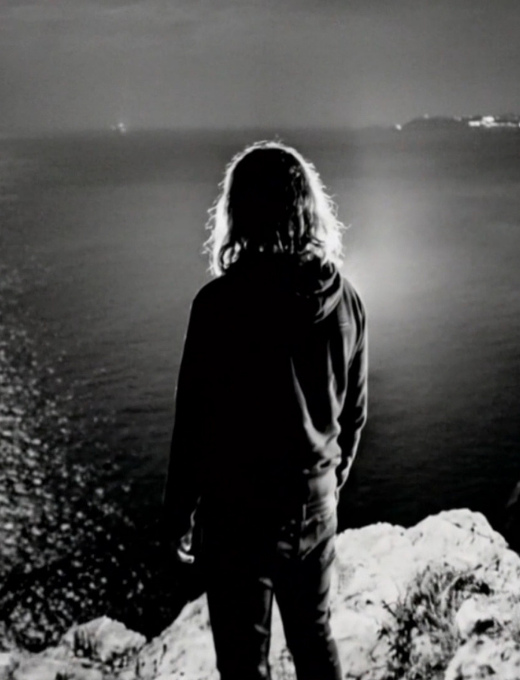 Silhouette féminine face à la mer, entre lumière et obscurité