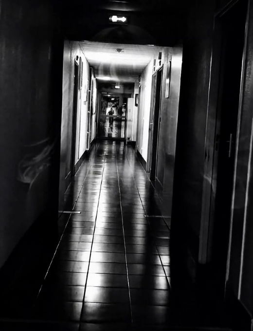 Couloir sombre et perspective infinie, évoquant un espace liminal